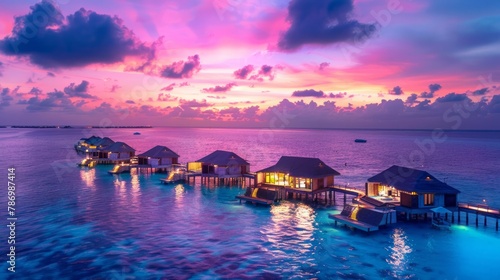 Amazing sunset panorama at Maldives. Luxury resort villas seascape with soft led lights under colorful sky. photo