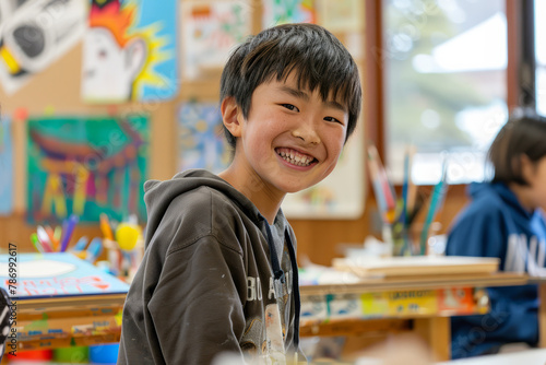 A Japanese boy grins with enthusiasm as he participates in an art and creativity class, embracing the opportunity for self-expression and exploration.