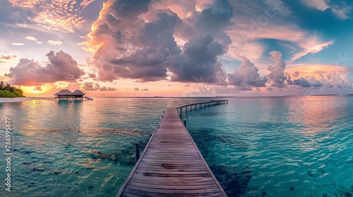 Sunset on Maldives island, luxury water villas resort and wooden pier. Beautiful sky and clouds and beach background for summer vacation holiday and travel concep photo