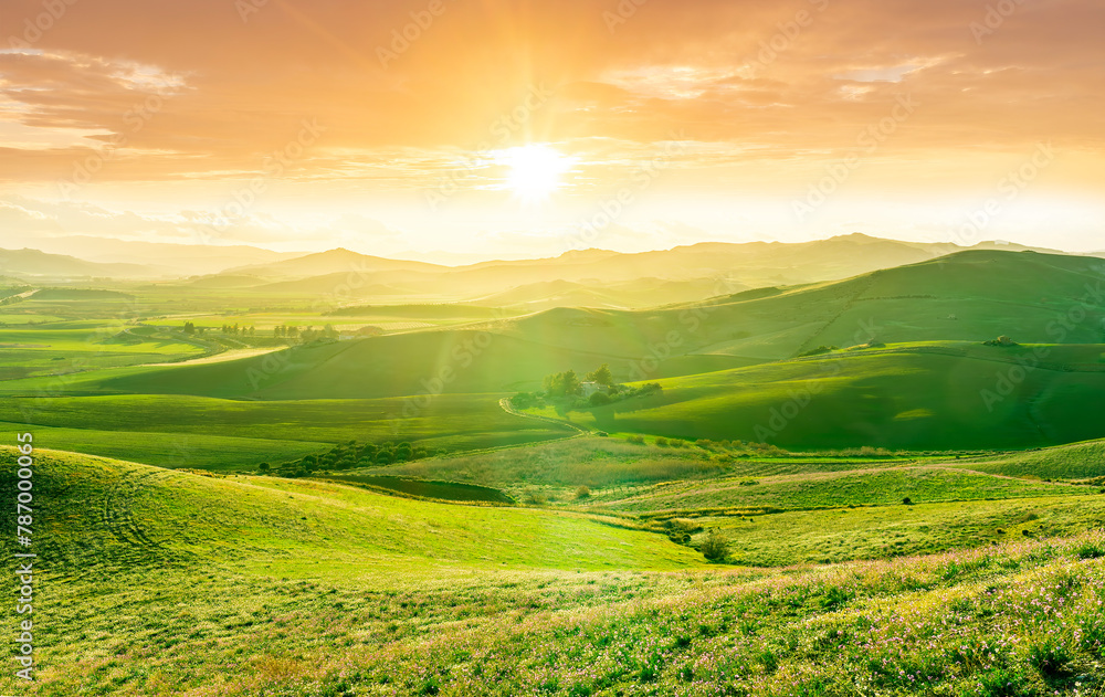beautiful green valley with green fields with green spring grass with nive hills and mountains and scrnic colorful cloudy sunset on background of landscape beautiful green valley with green fields with green spring grass with nive hills and mountains and scrnic colorful cloudy sunset on background of landscape