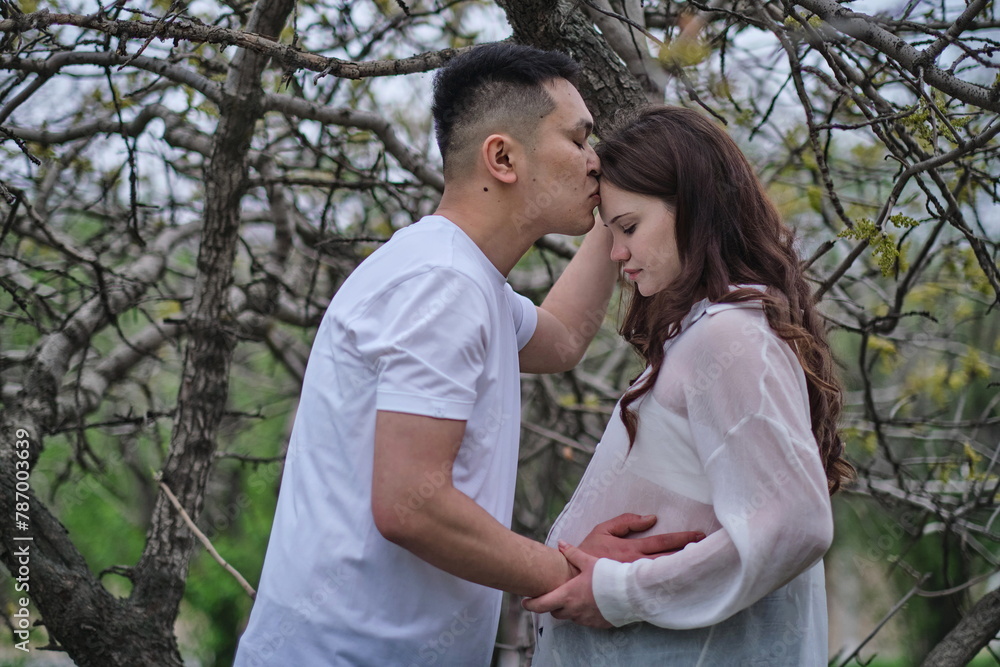 A photoshoot of a young interracial couple with a pregnant wife in nature A photoshoot of a young interracial couple with a pregnant wife in nature