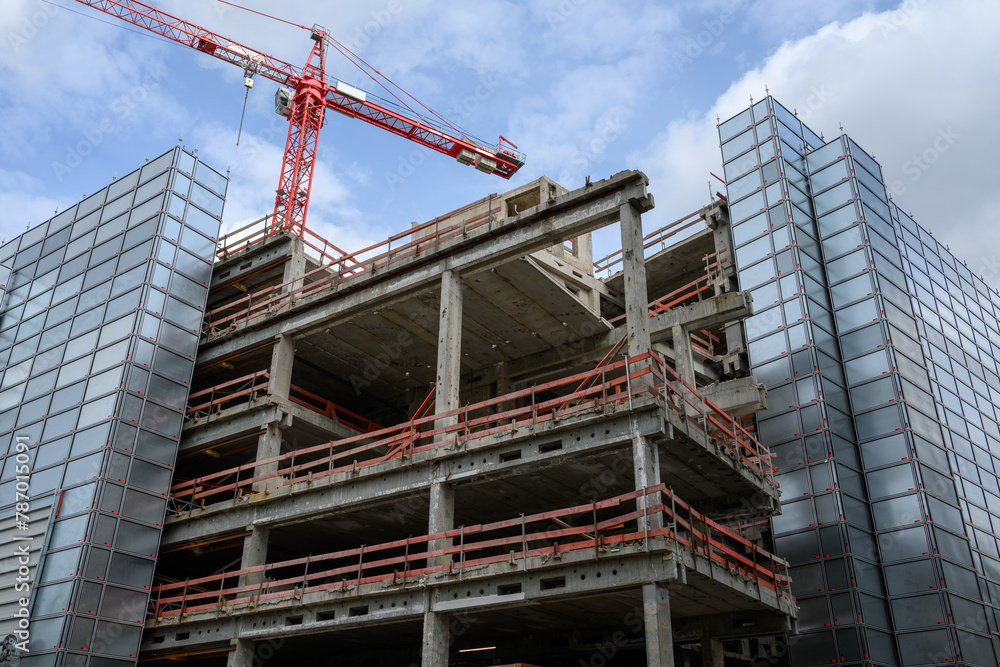 A construction site with a crane and the shell of a house A construction site with a crane and the shell of a house