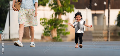 happy toddler girl running with her mother in park
