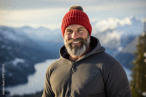 Portrait of a happy man in his 40s donning a warm wool beanie in panoramic mountain vista