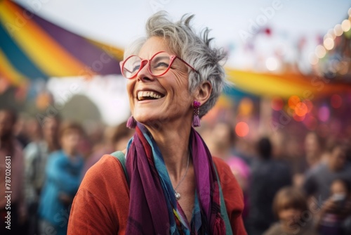 Portrait of a happy woman in her 60s wearing a comfy flannel shirt over vibrant festival crowd