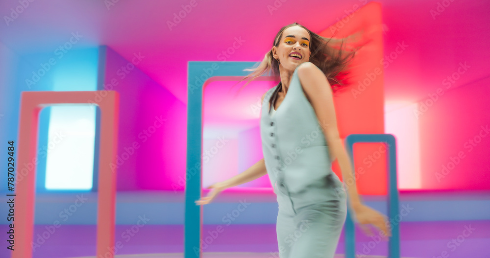 Portrait of a Talented Young Female Artist Showcasing Graceful Movements and Expressive Joyful Emotions with Her Innovative Modern Dance Routine in Colorful Neon Lit Spacious Studio