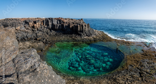 Cliffs aerials view of natural pools in Caleta de Fuste, a beautiful oasis with emerald clear waters in Fuerteventura island