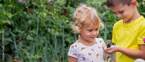 two happy children catch and admire butterflies