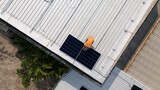 Aerial top view of a technician drone installing solar panels on the roof.