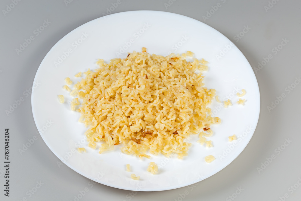 Boiled alphabet pasta on white dish on a gray background Boiled alphabet pasta on white dish on a gray background