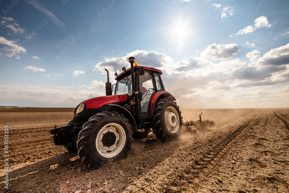 Agriculture machinery in action, a tractor plows a field on a bright day Agriculture machinery in action, a tractor plows a field on a bright day