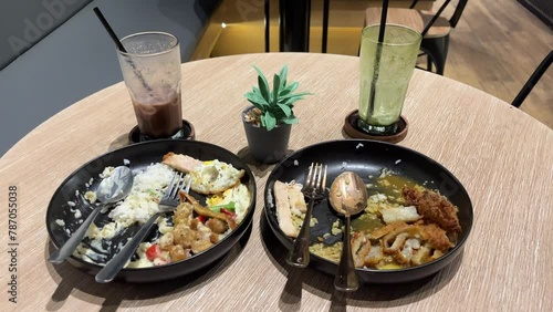 Leftover food and drink after dinner in the restaurant. Wasted food and drink on a plate on the table. 