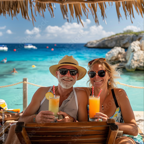 Old couple enjoying tropical drinks at a beach resort