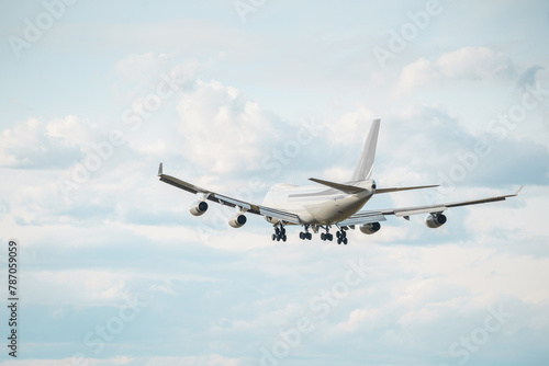 Rear view of a massive cargo plane is preparing to land amidst the clouds. Landing airplane.