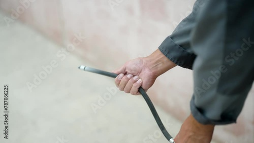 Close-up of hands operating a fire extinguisher during the accident. Using the balloon of powder extinguisher in case of fire, unrecognizable person. Stream comes out of the hose