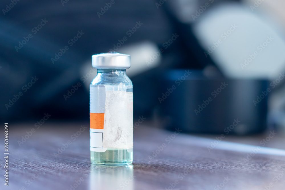 A small bottle labeled vaccine containing a liquid solution A small bottle labeled vaccine containing a liquid solution
