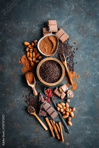 Schokolade, Nüsse und rote Pefferkörner auf einem dunklen Hintegrund. Rustikaler Stil, Draufsicht. photo