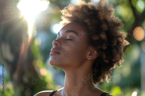 Woman with closed eyes and sun-kissed skin, highlighting her natural beauty and curly hair