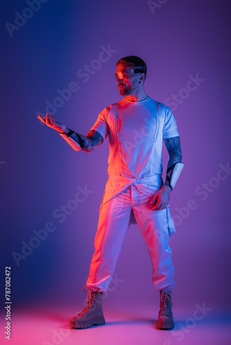 A man clad in a pristine white shirt and pants stands confidently in a virtual reality studio, his presence emanating elegance. © LIGHTFIELD STUDIOS