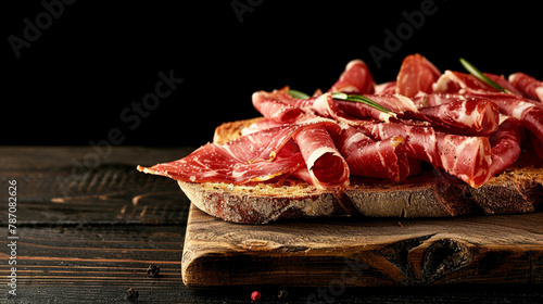 a wooden board with bread and ham and basil on it photo