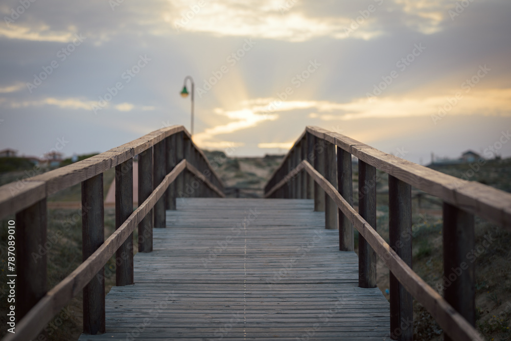 Boardwalk leading to a sunset sky with some clouds