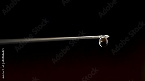 Syringe Needle with Droplet on Dark Background photo