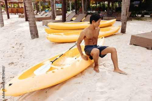 Happy Asian Man Kayaking on a Tropical Beach: Enjoying Summer Vacation Adventure photo