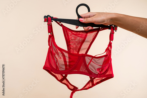 female hand choose perfect elegant red transparent underwear in hanger at store