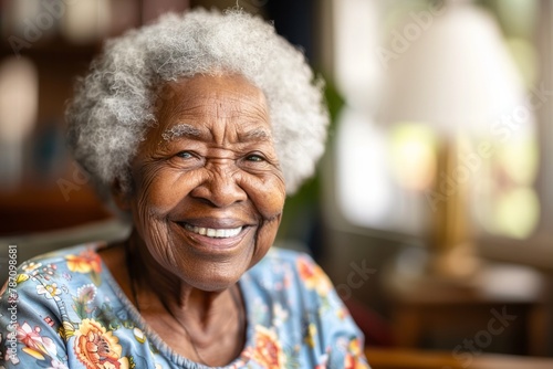 Close up portrait of kind black senior woman smiling at camera at home, copy space photo