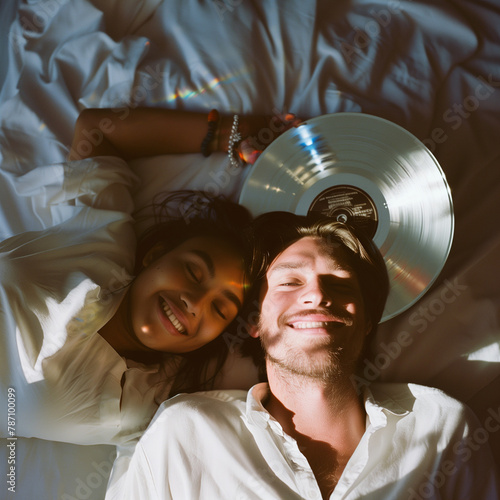 Smiling people in bed with a vinyl record in hand.Minimal creative party and interior concept.Flat laay photo