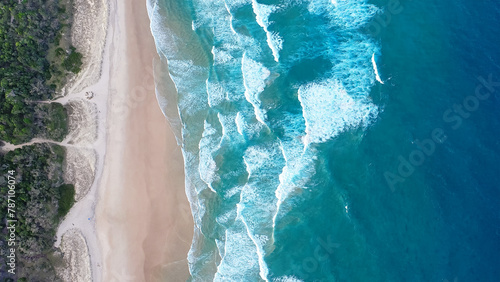 Bild auf Leinwand Foamy ocean waves roll and approach sandy beach