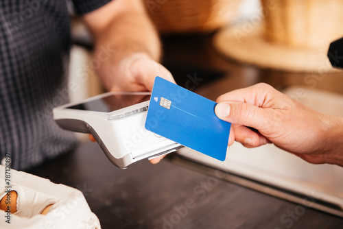 Fotografi Close-Up of Hand Holding Credit Card for Payment at Grocery Store Checkout