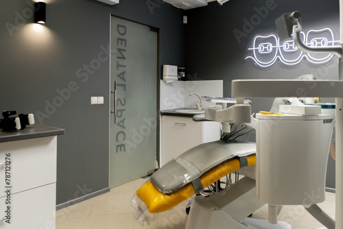 a dental office white sterile ready for robots yellow chair for the patient and white equipment photo