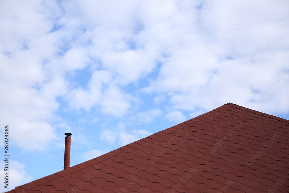 beautiful house roof, brown, against the blue sky

