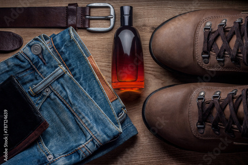 Men's Boots, jeans, belt, wallet, perfum on wood table
