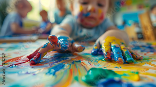 Toddler with paint on hands and face. photo
