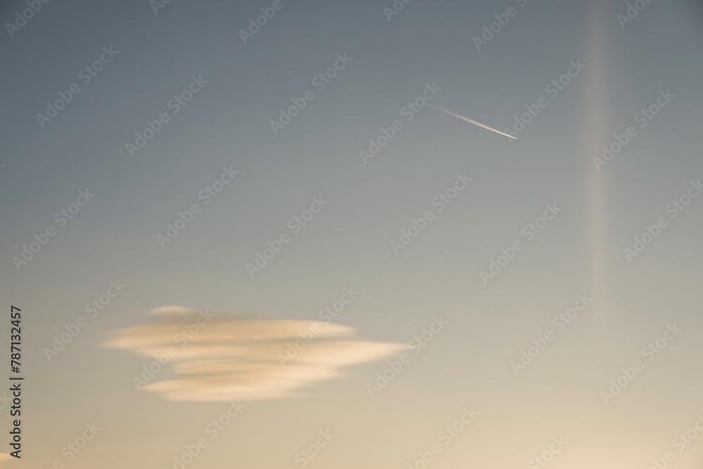 single soft colorful cloud with a aeroplane on the sky during sundown
