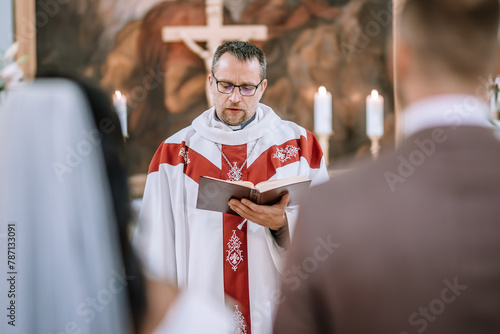 Tableau sur toile Valmiera, Latvia- July 28, 2024 - A priest in liturgical vestments reads from a book during a ceremony