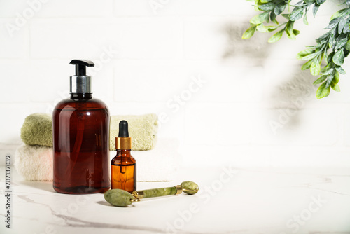 Beauty products in the bathroom on white background. Soap, serum bottle, jade roller. Skin care.