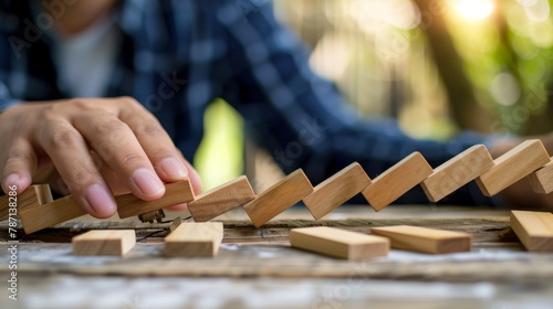 Metaphor of crisis management. A man stops dominoes from falling. photo