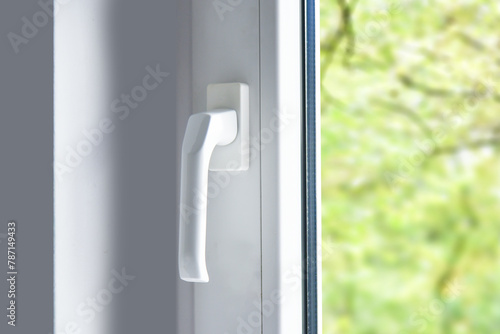 Handle of modern pvc plastic window in room, close up view