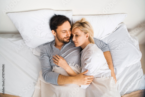 Sleeping couple. Blond woman, bearded man lay on home bed in bedroom - love, relationship, dating, happy family, husband and wife, comfortable, waiting child concept image.