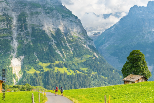 Two sporty woman hiking in Switzerland alps. Heathy lifestyle, sport, beauty in nature. Grindelwald valley, Swizz