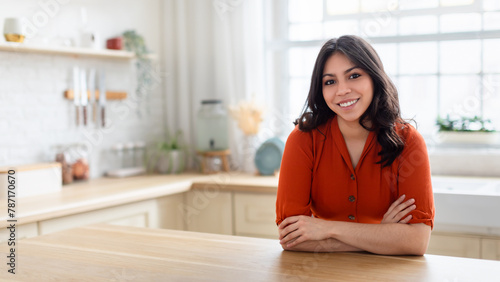 Smiling woman in orange blouse at home