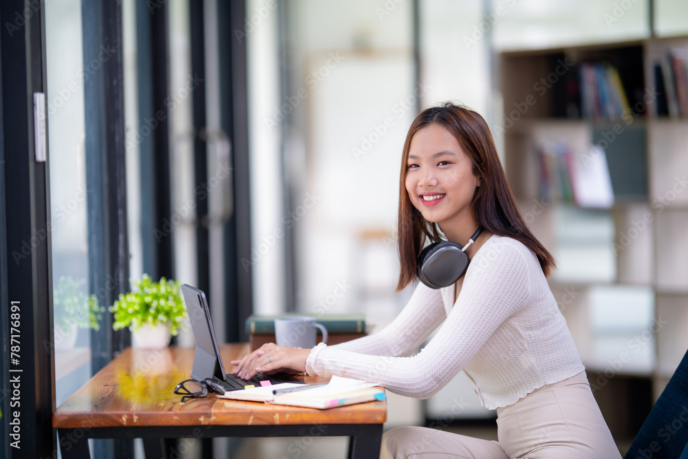 Relaxed young woman smiling as she browses on her tablet, sitting comfortably in a bright modern home. Relaxed young woman smiling as she browses on her tablet, sitting comfortably in a bright modern home.