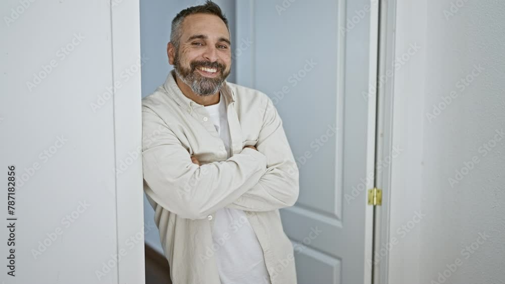 Mature bearded man with grey hair smiling by home entrance Mature bearded man with grey hair smiling by home entrance