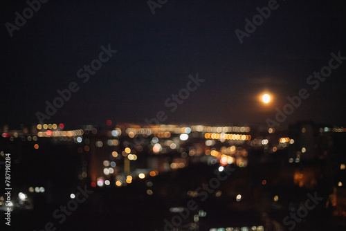 Defocused photograph of Moon over night city