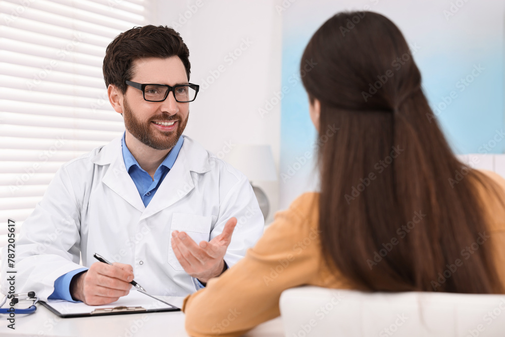 Doctor consulting patient during appointment in clinic Doctor consulting patient during appointment in clinic