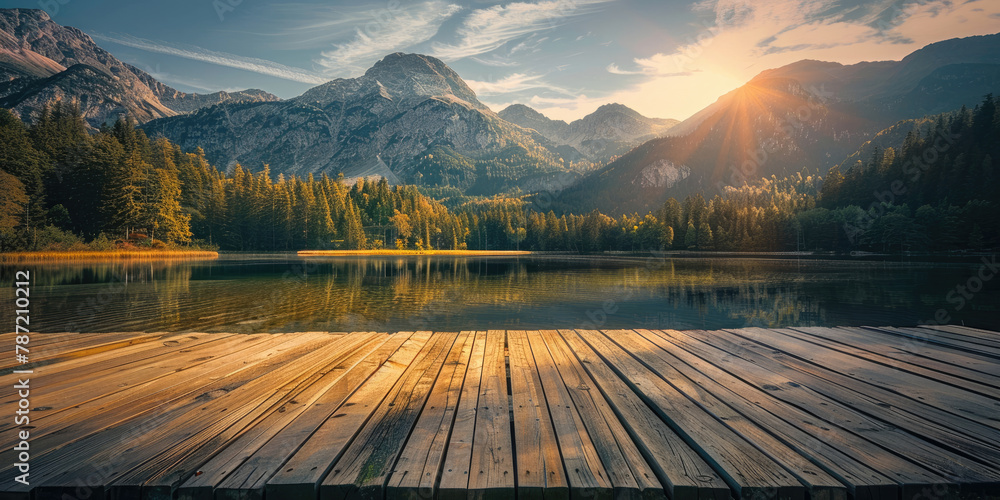 Wooden pier on the lake with the view of the mountains and forest at sunset