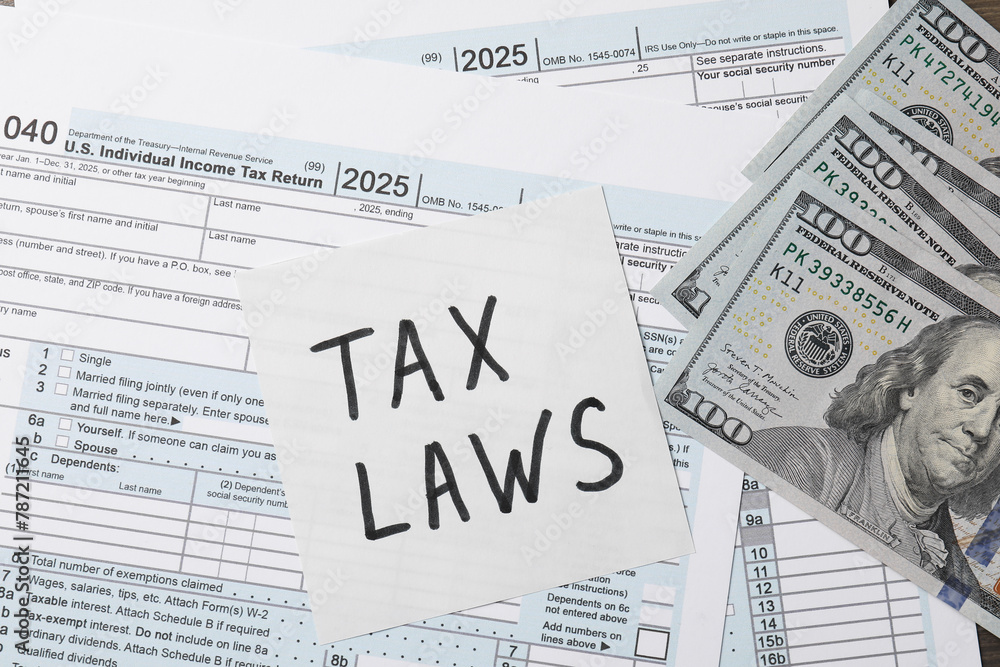Note with words Tax Laws, forms and dollar banknotes, top view Note with words Tax Laws, forms and dollar banknotes, top view